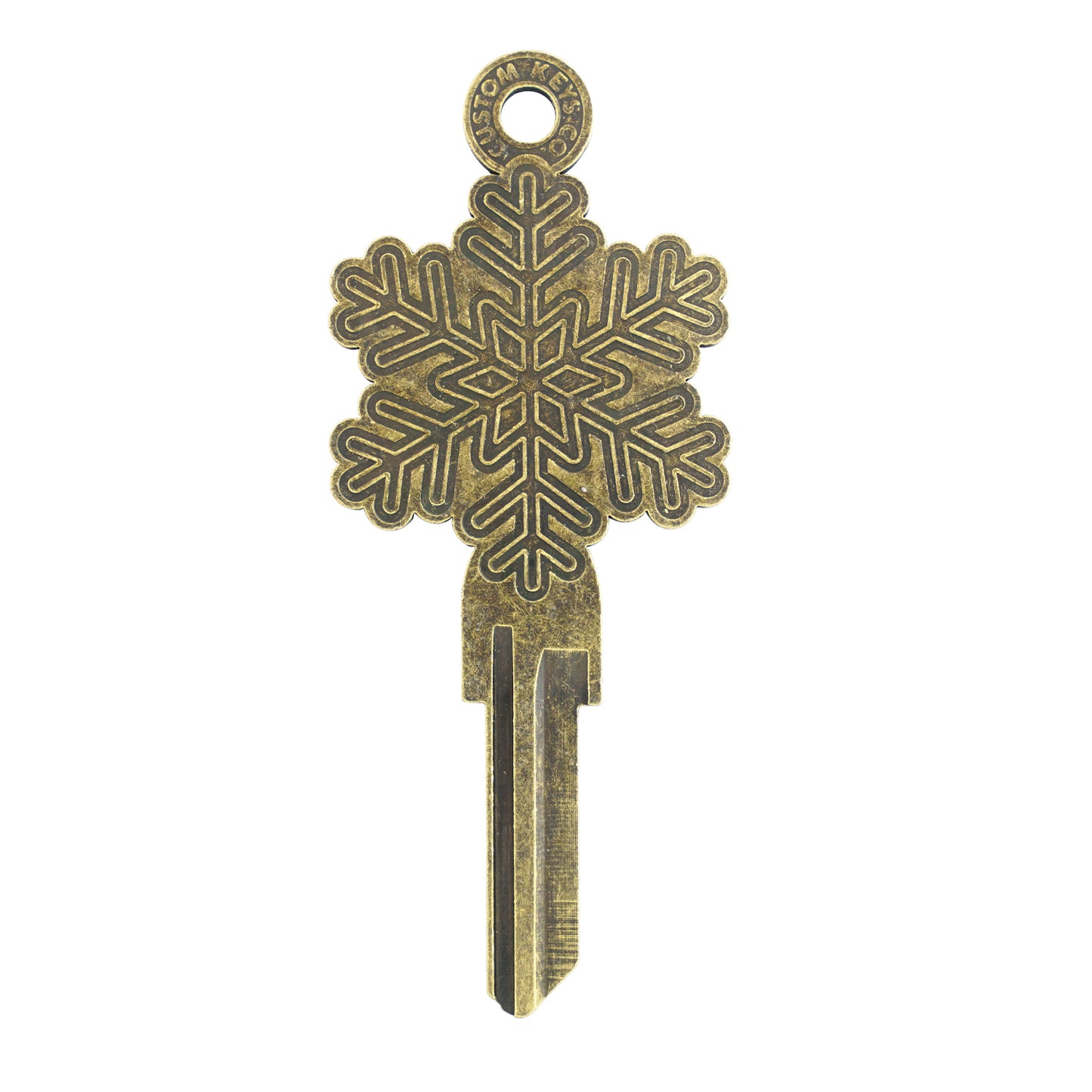 Gold key on white background with snowflake design.