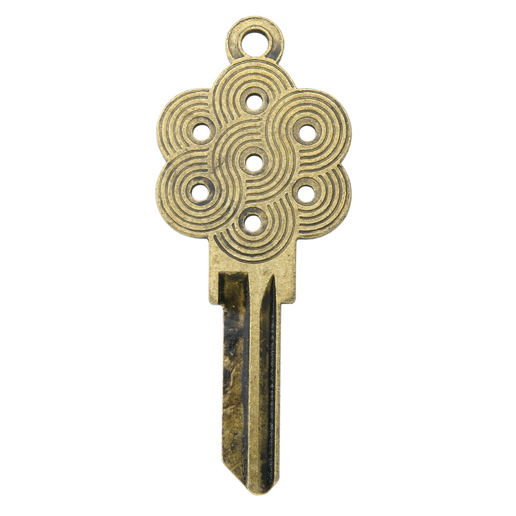 Brass key on white background with geometric design.