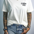 Tattooed woman wearing a white t-shirt with 'Custom Keys.com' text on a white background