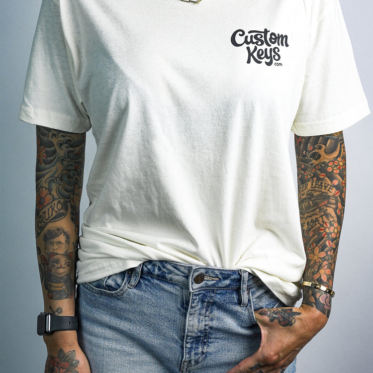 Tattooed woman wearing a white t-shirt with 'Custom Keys.com' text on a white background
