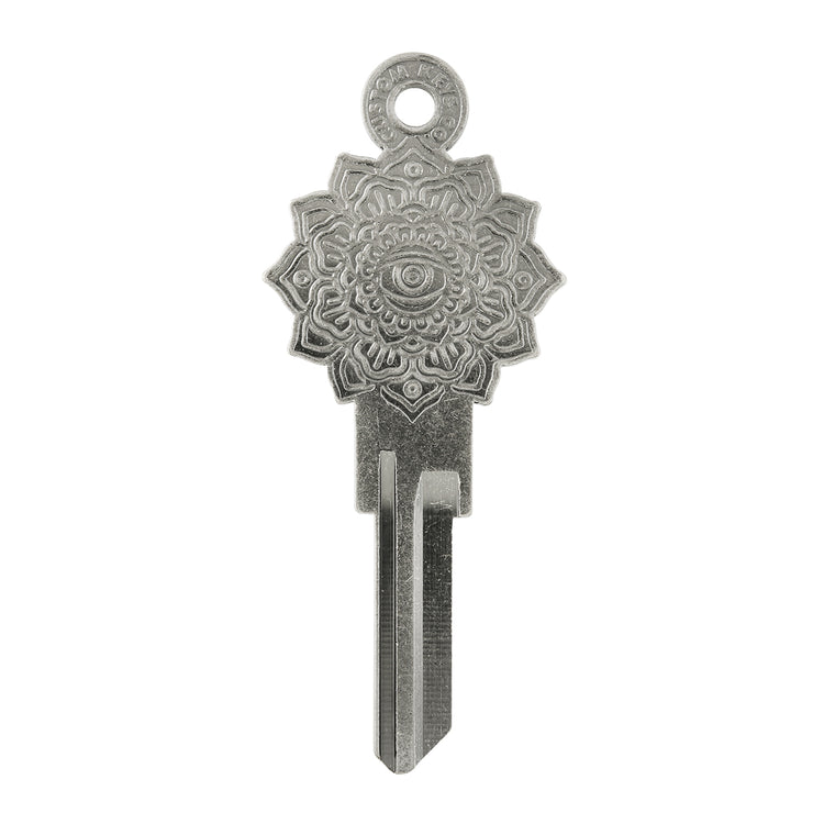 Silver key on white background with mandala design.