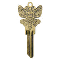 Brass key on white background with death moth design.