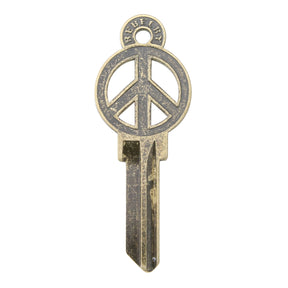 Brass key on white background with peace sign design.