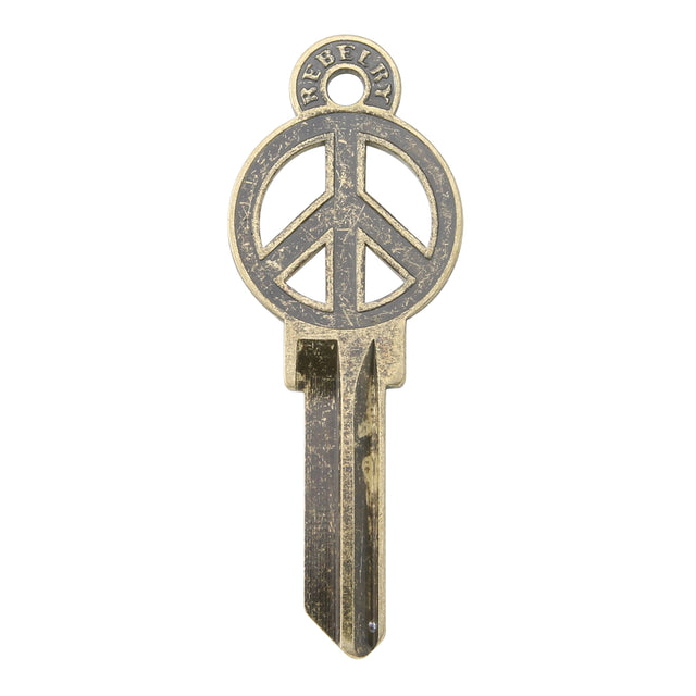 Brass key on white background with peace sign design.