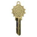 Brass key on white background with spiderweb design.
